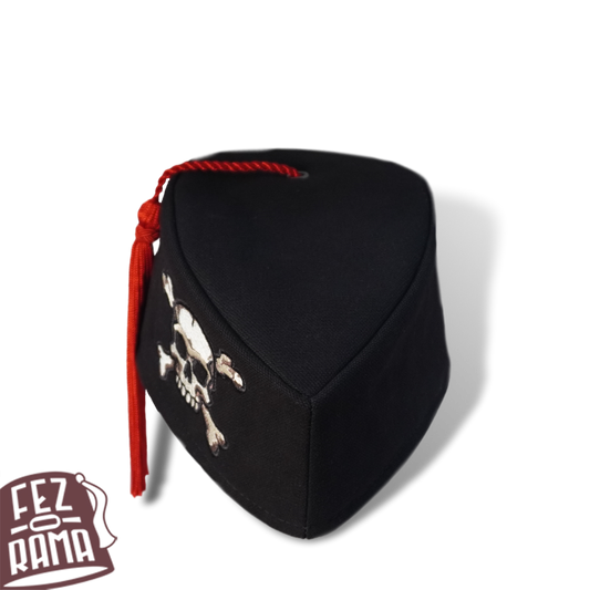 The front view of the canvas Fez-o-Chapeau cap with a skull and crossbones embroidery on the side and a red tassel